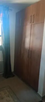a room with a large wooden door and a curtain at Apartman M&M in Jagodina