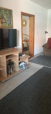 a living room with a television and a mirror at Apartman M&M in Jagodina
