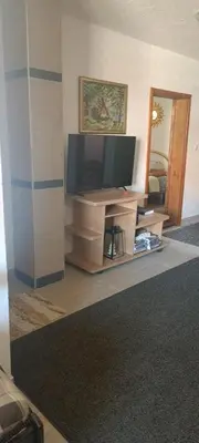 a living room with a flat screen tv on a stand at Apartman M&M in Jagodina