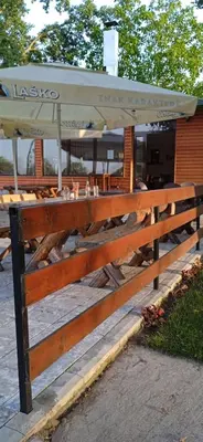 a wooden fence with a table with an umbrella at Apartman M&M in Jagodina