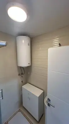 a small bathroom with a toilet and a refrigerator at Vrnjačka View apartments in Vrnjačka Banja