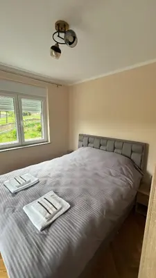 a bedroom with a bed with two towels on it at Vrnjačka View apartments in Vrnjačka Banja