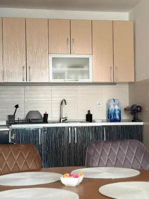 a kitchen with a sink and a table with chairs at DarViva Apartment Niš, center, private garage parking, river view in Niš