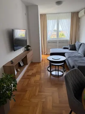 a living room with a couch and a table at DarViva Apartment Niš, center, private garage parking, river view in Niš