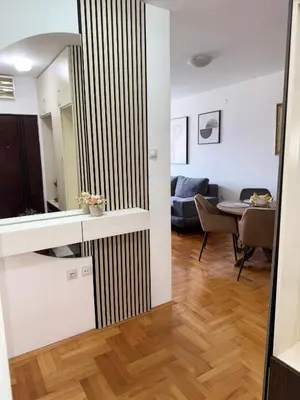 a kitchen and living room with a striped wall at DarViva Apartment Niš, center, private garage parking, river view in Niš