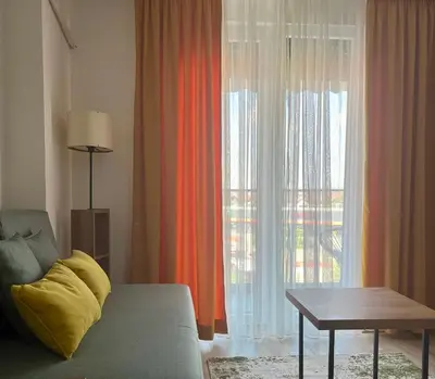 a living room with a couch and a large window at Kalamata apartman, K Kompleks Jagodina in Trnava