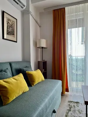 a living room with a blue couch with yellow pillows at Kalamata apartman, K Kompleks Jagodina in Trnava