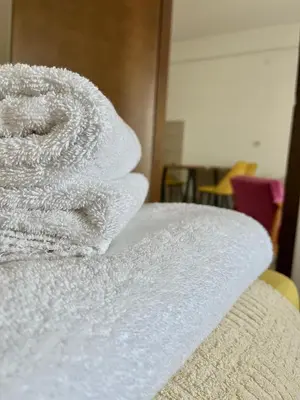 a stack of white towels sitting on top of a bed at Kalamata apartman, K Kompleks Jagodina in Trnava