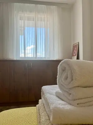 a bedroom with a bed with a window and towels at Kalamata apartman, K Kompleks Jagodina in Trnava
