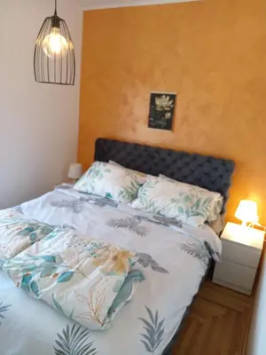 a bedroom with a bed with a blue and white comforter at Apartmani Slatinska Oaza in Vrnjačka Banja