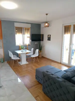 a living room with a couch and a table and chairs at Apartmani Slatinska Oaza in Vrnjačka Banja