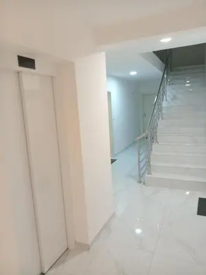 a hallway with white walls and stairs in a building at Apartmani Slatinska Oaza in Vrnjačka Banja