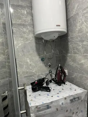 a room with a shower with a tank and a table at Gudzic in Vrnjci