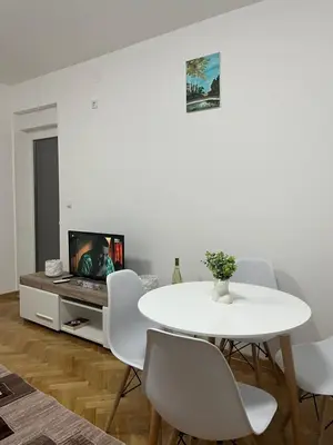 a white dining room with a white table and chairs at Gudzic in Vrnjci