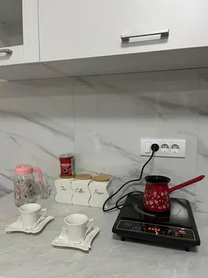 a kitchen counter with two cups and a stove at Gudzic in Vrnjci