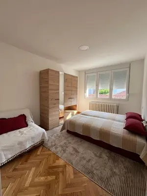 a bedroom with a large bed and a wooden floor at Kika in Prokuplje