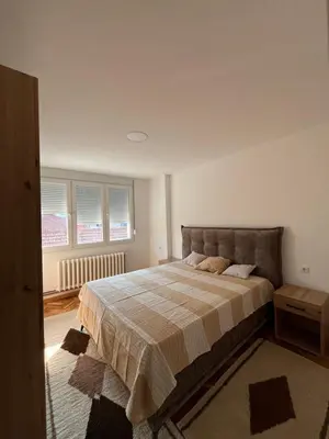a bedroom with a bed and two windows at Kika in Prokuplje