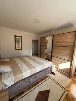 a bedroom with a bed and a wooden wall at Kika in Prokuplje