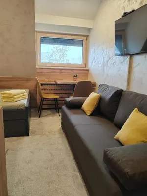a living room with a couch and a piano at Kopaonik centar - Konaci, lux apartment ANDREA in Kopaonik