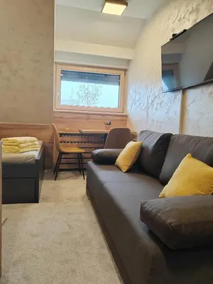 a living room with a couch and a piano at Kopaonik centar - Konaci, lux apartment ANDREA in Kopaonik
