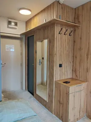a bedroom with a mirror and a wooden wall at Kopaonik centar - Konaci, lux apartment ANDREA in Kopaonik