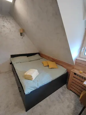 a small bedroom with a bed with towels on it at Kopaonik centar - Konaci, lux apartment ANDREA in Kopaonik
