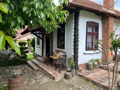 a small white house with a table and chairs at Etno kuća Danica in Senje