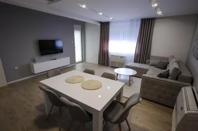 a living room with a white table and a couch at Apartmani Lepojevic in Prokuplje