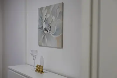 a white room with a picture of a flower on the wall at Apartmani Lepojevic in Prokuplje