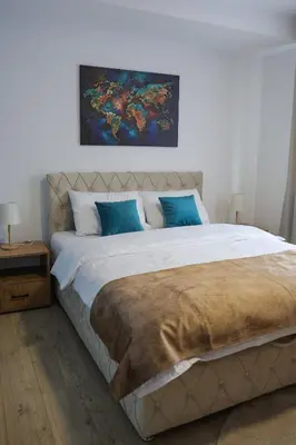 a bedroom with a large bed with blue pillows at Apartmani Lepojevic in Prokuplje
