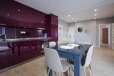 a kitchen with purple cabinets and a blue table and chairs at Apartmani Lepojevic in Prokuplje