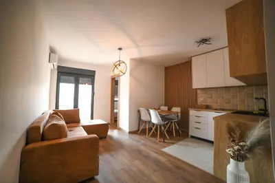 a living room and kitchen with a couch and a table at Apartmani S in Vrnjačka Banja