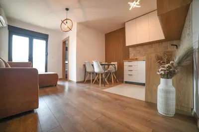 a kitchen and living room with a vase of flowers at Apartmani S in Vrnjačka Banja