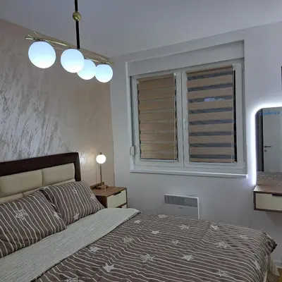 a bedroom with a bed and two windows at Ljubičica deluxe 2, sa dvorištem i parkingom in Vrnjačka Banja