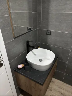 a bathroom with a white sink on a counter at Raccoon Paradise Apartment Residence Hill B19 in Kopaonik