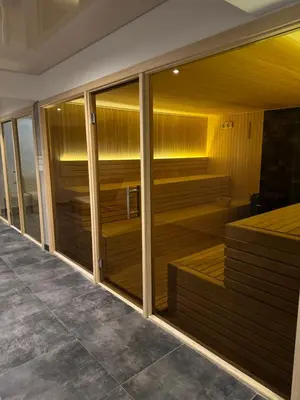 a sauna with wooden floors and glass walls at Raccoon Paradise Apartment Residence Hill B19 in Kopaonik
