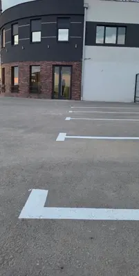 an empty parking lot in front of a building at SEE YOU Apartments in Niš
