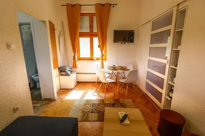 a small living room with a table and a window at Ilić Sokobanja in Soko Banja