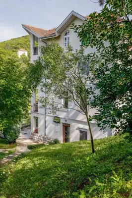 a white house with a tree in front of it at Ilić Sokobanja in Soko Banja