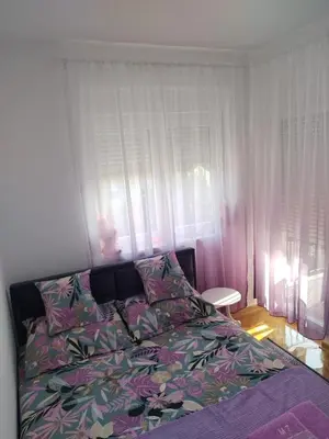 a bedroom with a bed and a window at Banjski kutak in Vrnjačka Banja