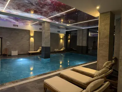 a swimming pool with lounge chairs in a building at Squirrel Viewpoint Apartment Residence Hill B124 in Kopaonik