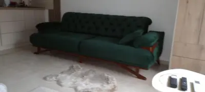 a green couch in a living room with a cat at Apartmant Novaković in Vrnjačka Banja