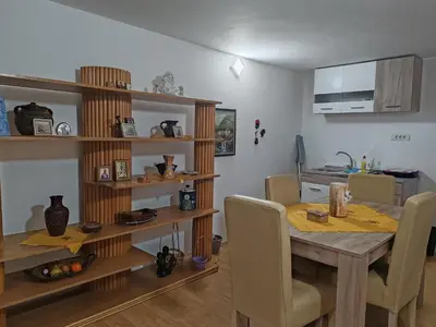 a dining room with a wooden table and chairs at Apartmani Pegasus in Vranje