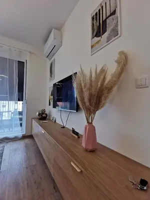 a living room with a vase on a wooden table at Apartman Taris in Vrnjačka Banja