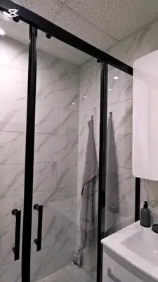 a bathroom with a shower with a white marble wall at Apartman Taris in Vrnjačka Banja