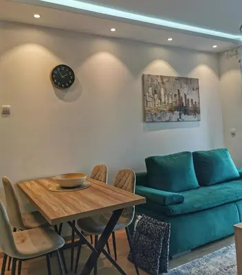 a living room with a table and a couch at Apartman Taris in Vrnjačka Banja