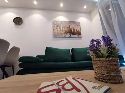 a living room with a green couch and a table at Apartman Taris in Vrnjačka Banja