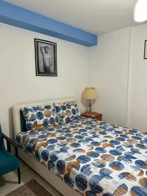 a bedroom with a bed with a blue headboard at Apartmani Miodragović - nedaleko od Snežnika, 100 metara pre bazena in Vrnjačka Banja