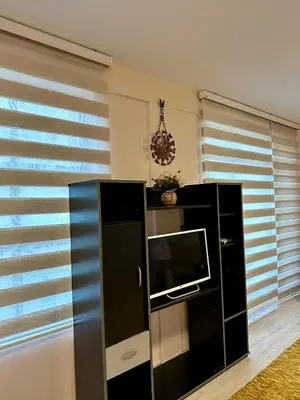 a living room with a television and a black cabinet at Apartmani Miodragović - nedaleko od Snežnika, 100 metara pre bazena in Vrnjačka Banja