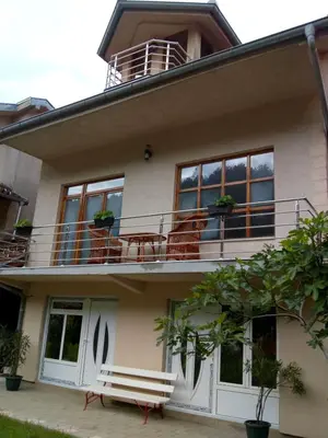 a house with a balcony with chairs on it at Apartmani Miodragović - nedaleko od Snežnika, 100 metara pre bazena in Vrnjačka Banja